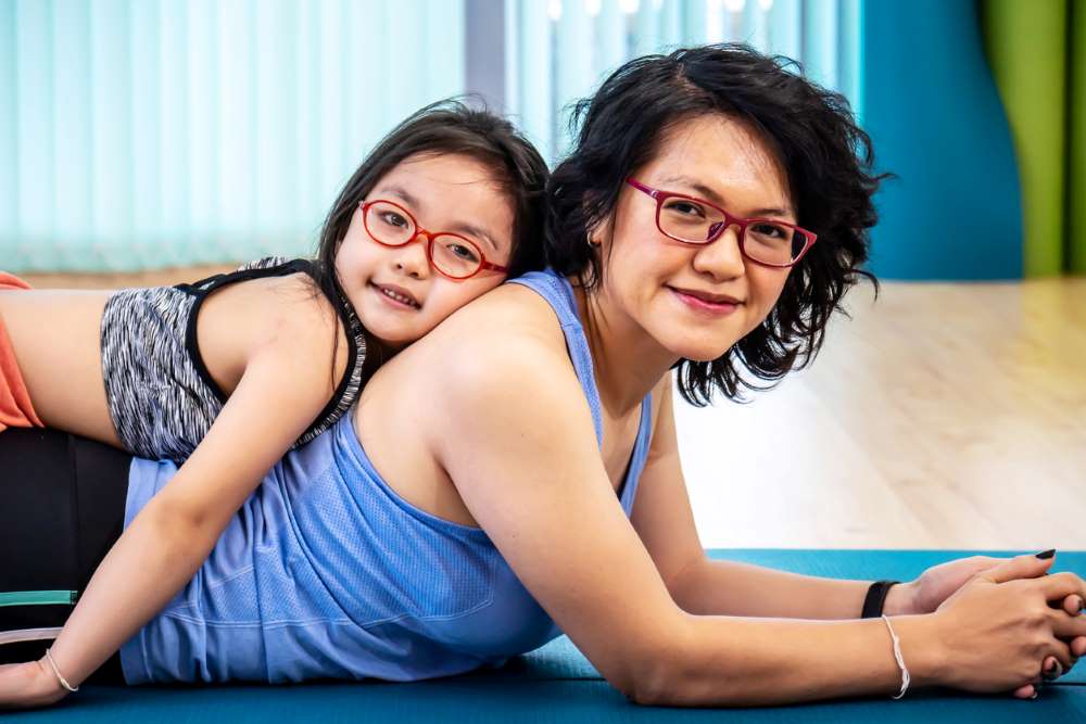 healthy fit parent doing yoga with a child